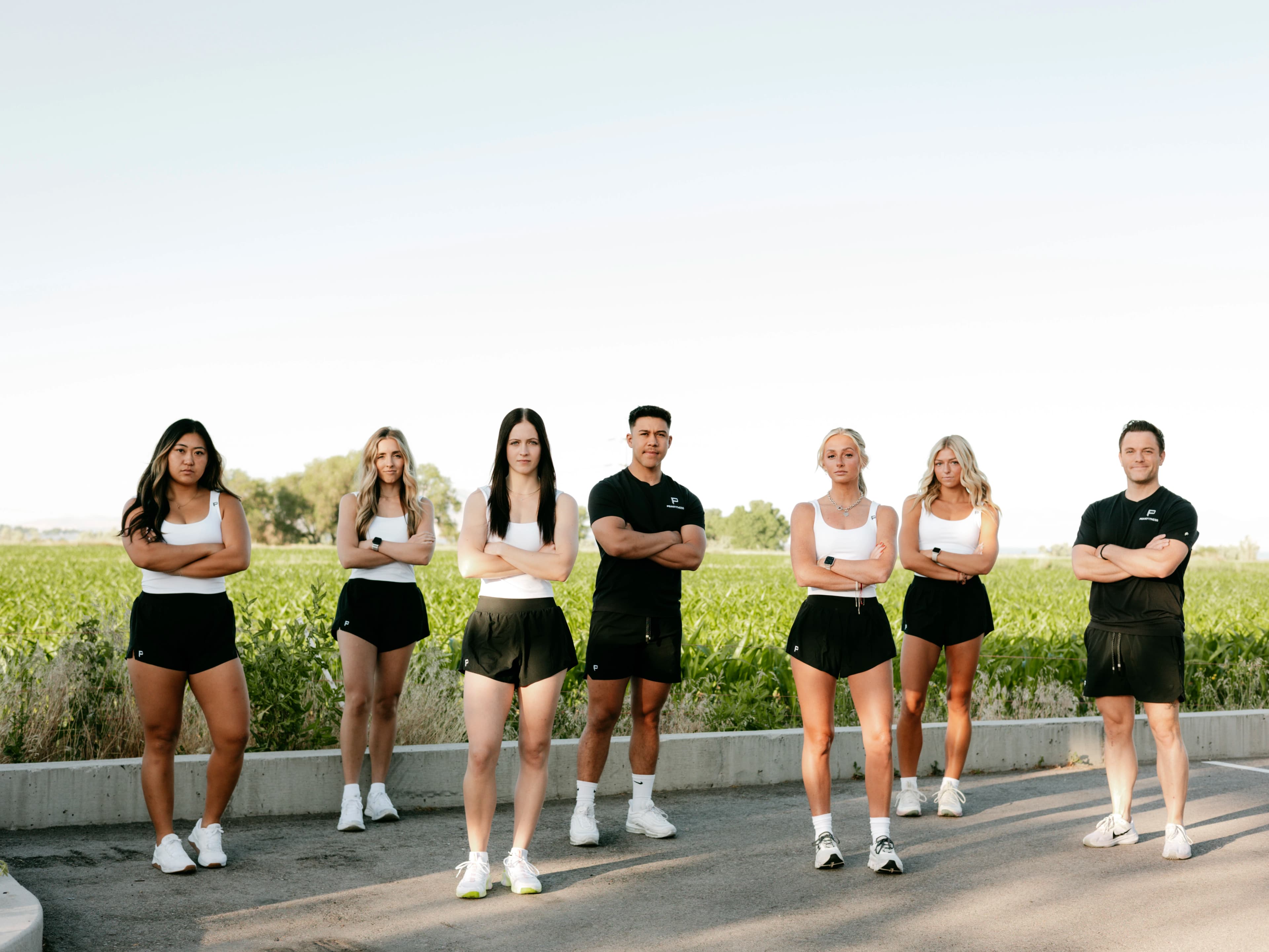 Peak Fitness trainer helps female member with upper body exercise