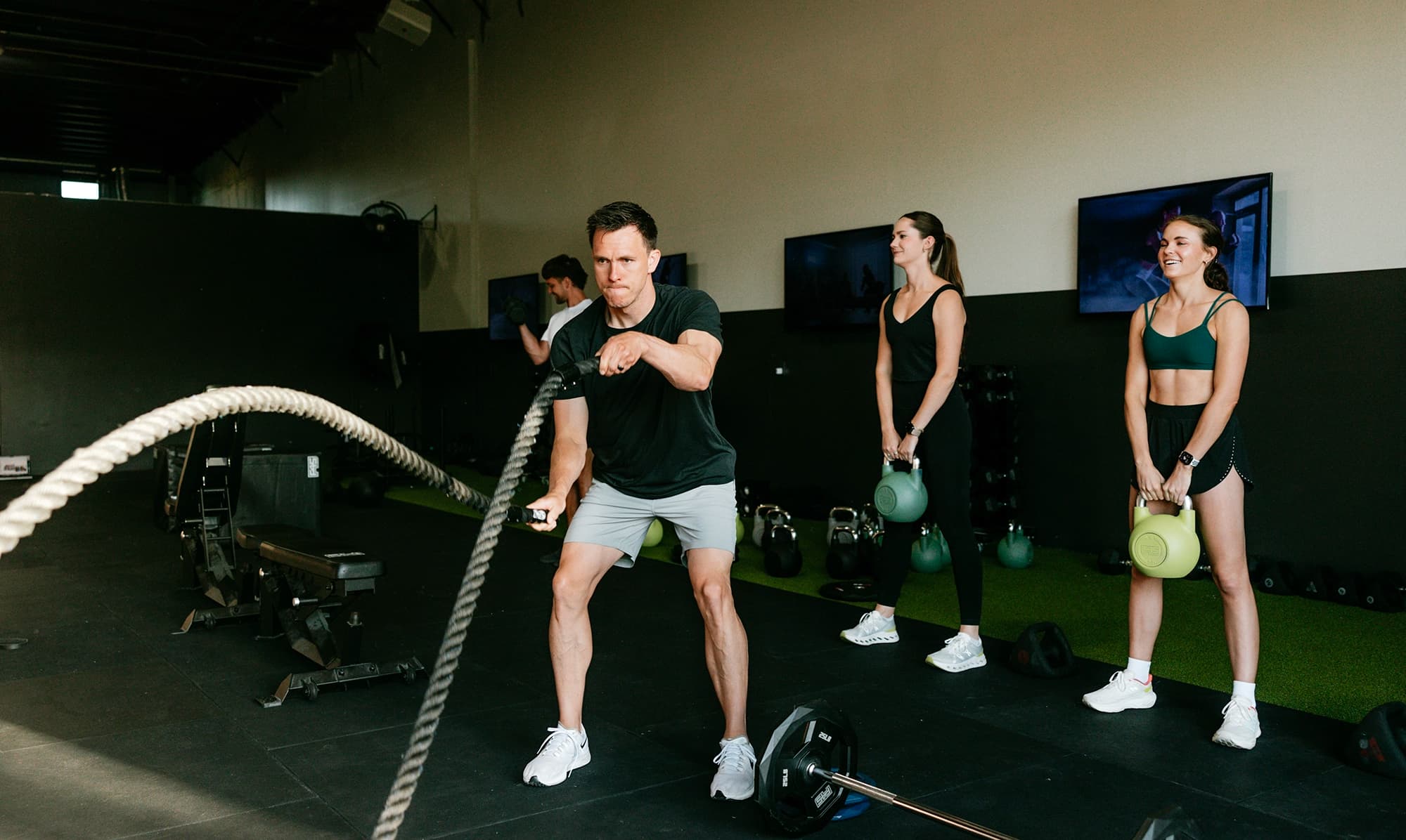 Member performs battle rope exercise