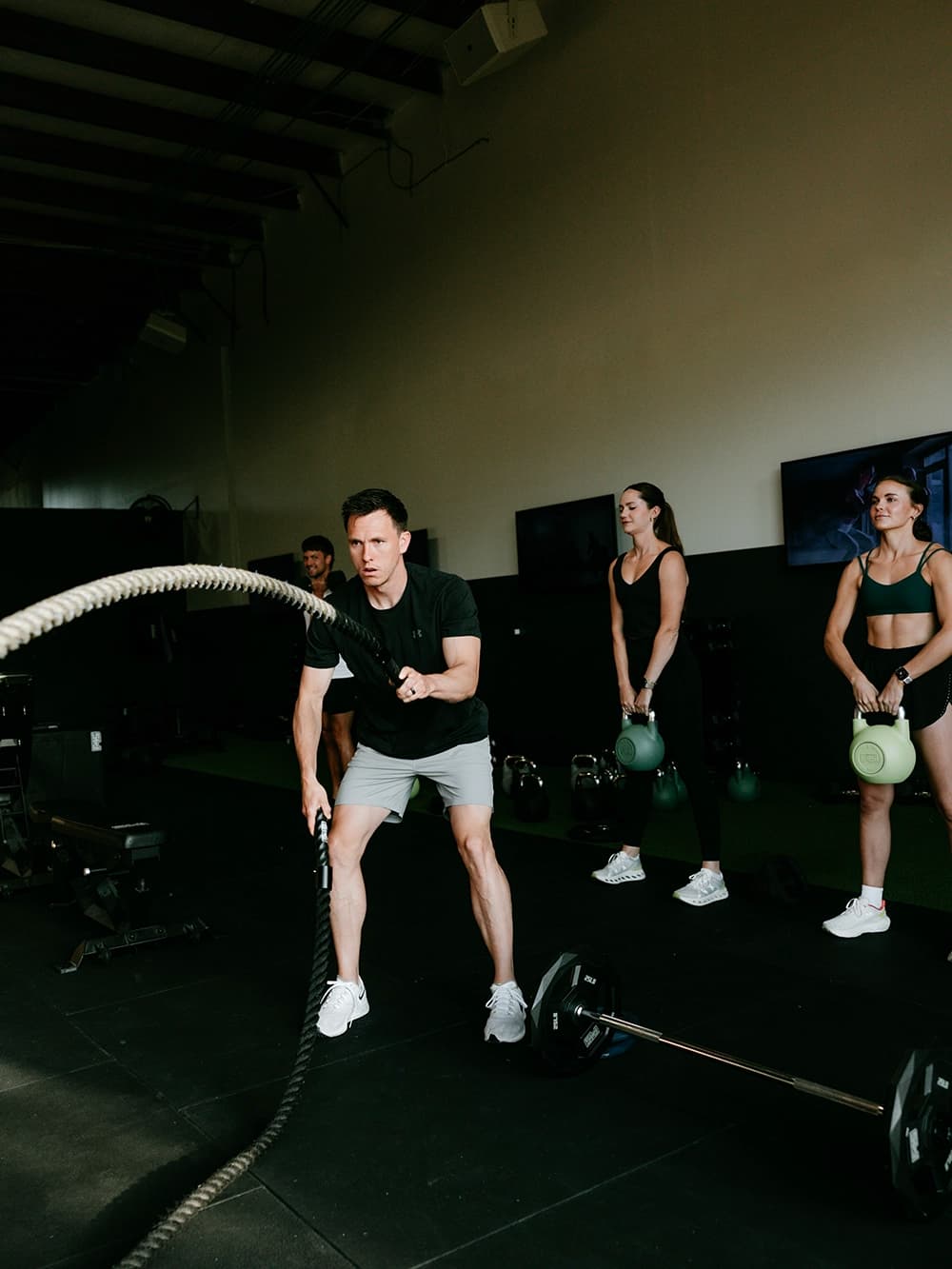 Member performs battle rope exercise